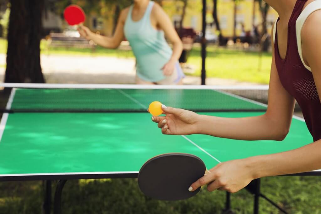 zwei Frauen spielen Tischtennis im Freien