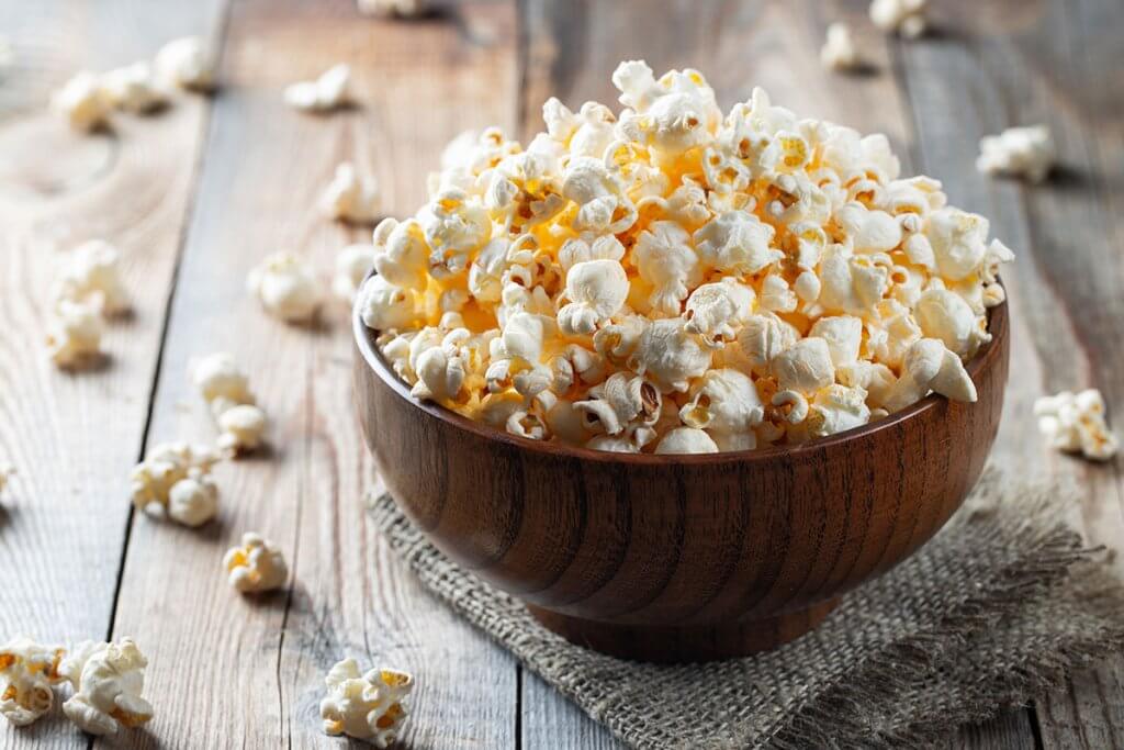 Frisches Popcorn in Holzschale auf Holztisch