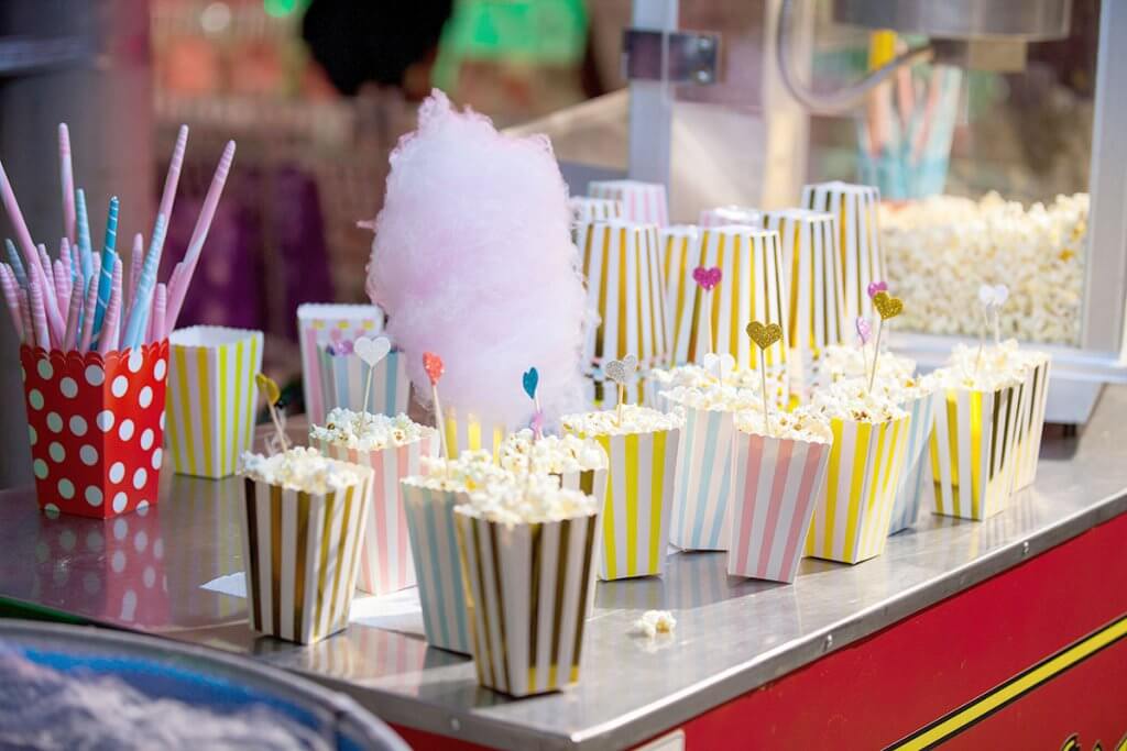 Grosse Popcornmaschine mit Popcorntueten und Zuckerwatte