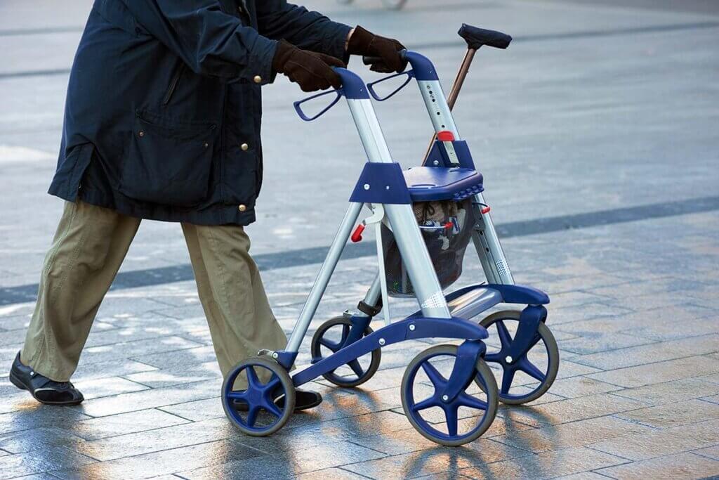 Senior geht mit Rollator durch die Stadt