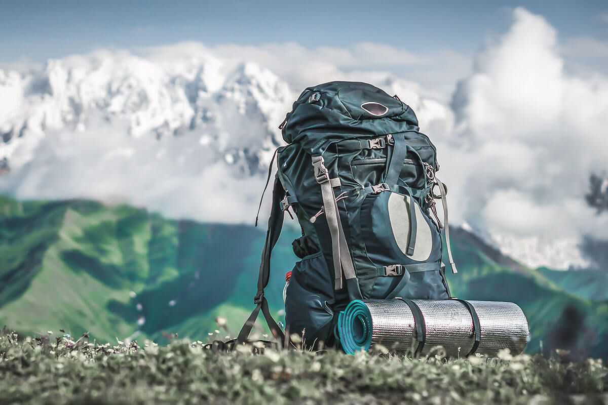 Gepackter Wanderrucksack samt Isomatte in Berglandschaft