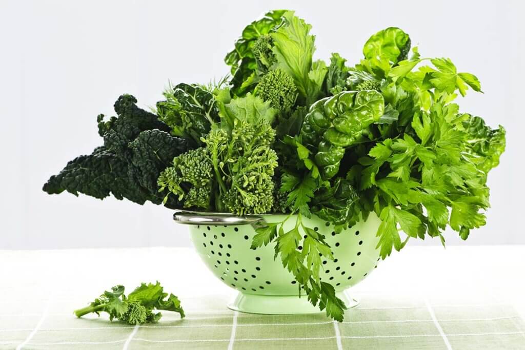 Gemüse und Kräuter in grüner Schüssel