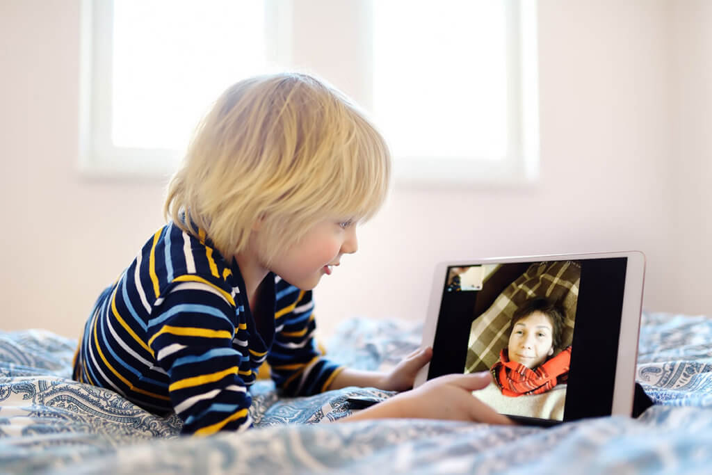 Junge nutzt Videochat am Tablet