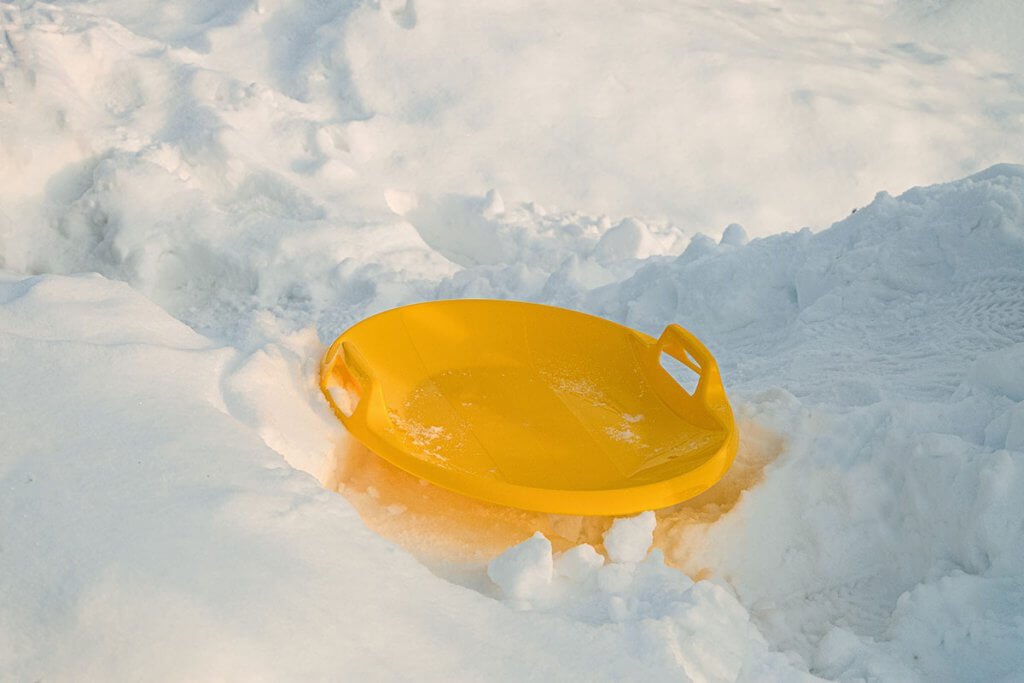 gelber Rutschteller im Schnee