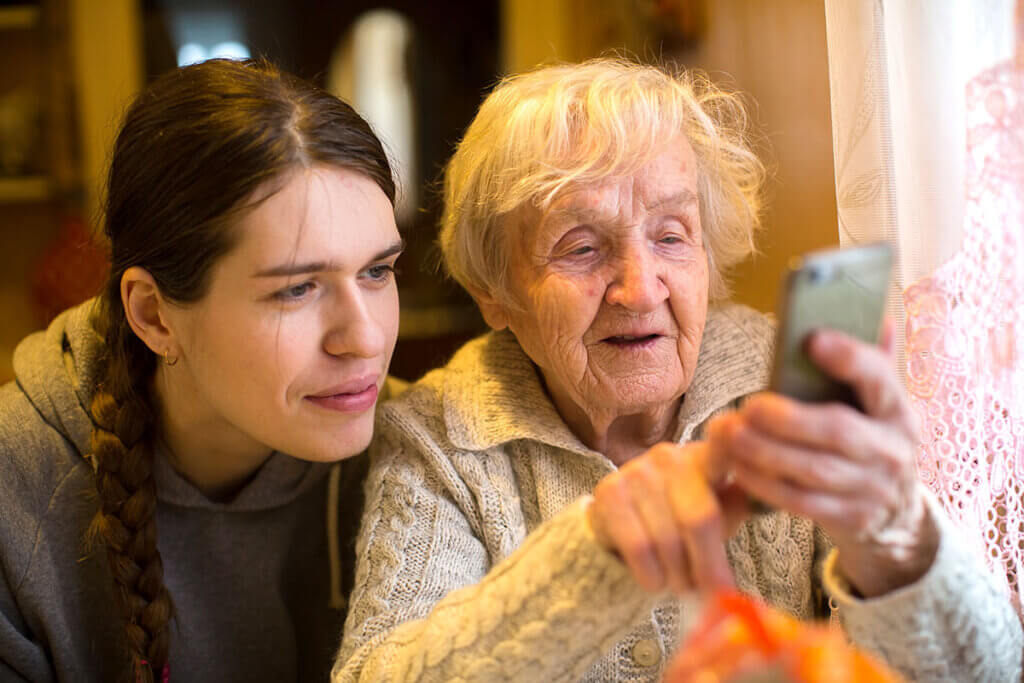 ältere Dame zeigt Frau etwas auf Smartphone
