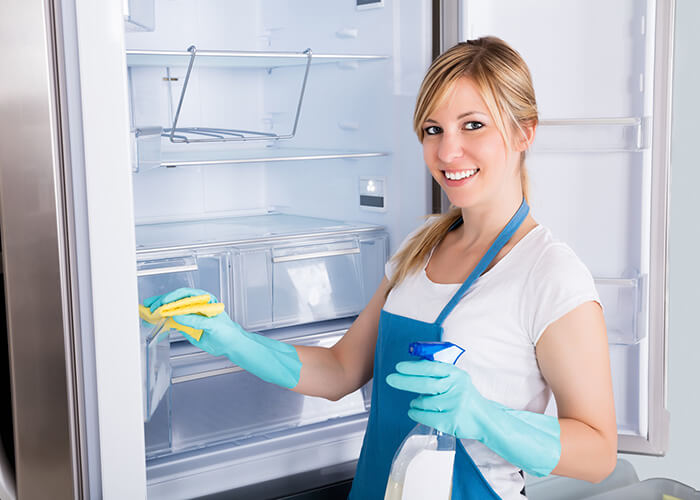 Frau reinigt Kühlschrank