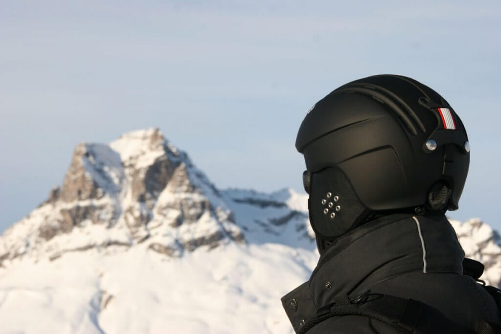 Person traegt Skihelm in Gebirge