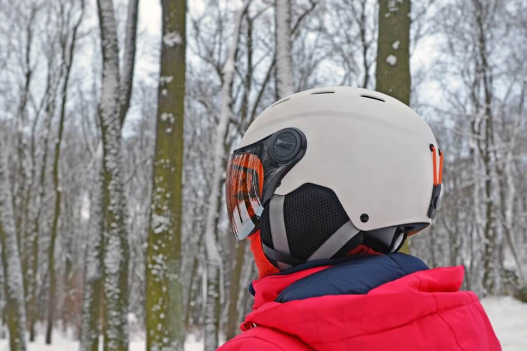 person mit skihelm, steht im Wald