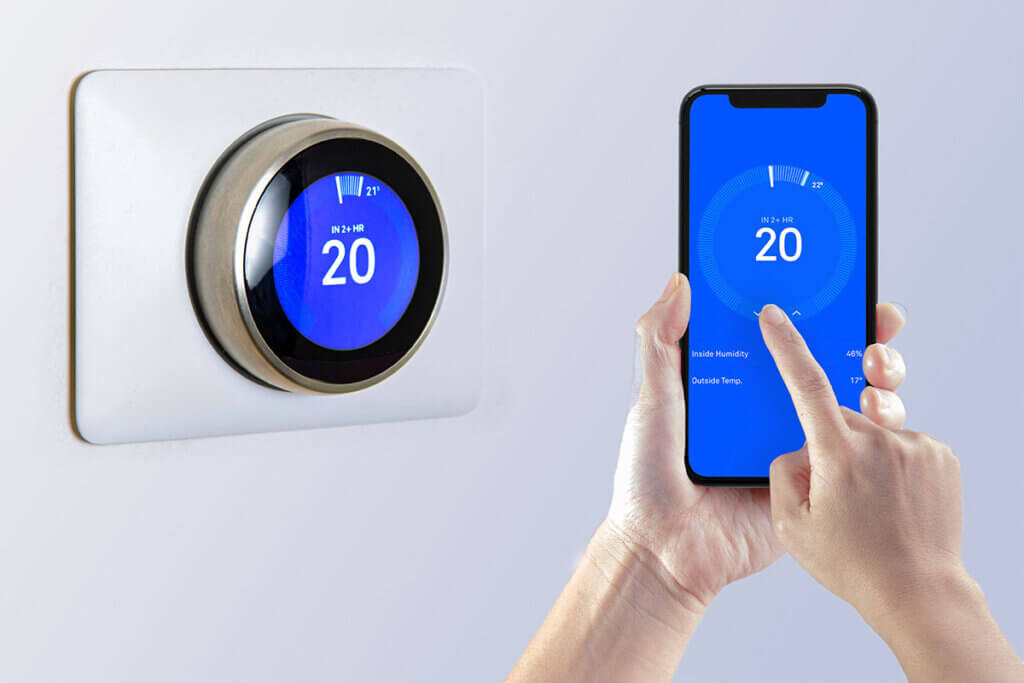 person bedient smartes Raumthermostat per Samrtphone