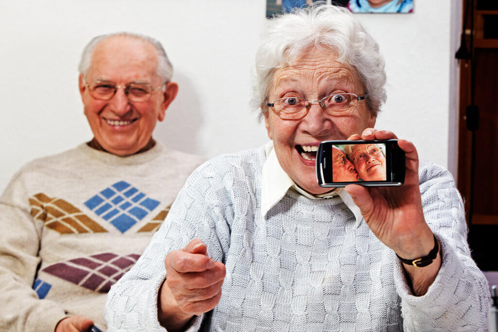 Senioren mit Smartphone laecheln