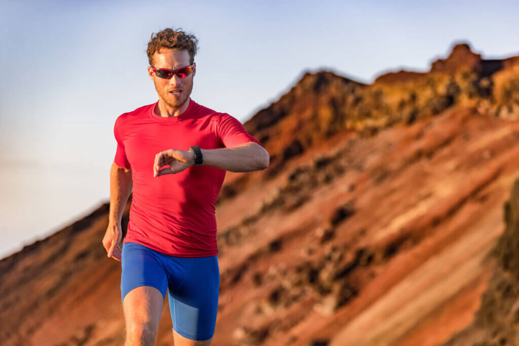 Person schaut beim Laufen auf Sportuhr