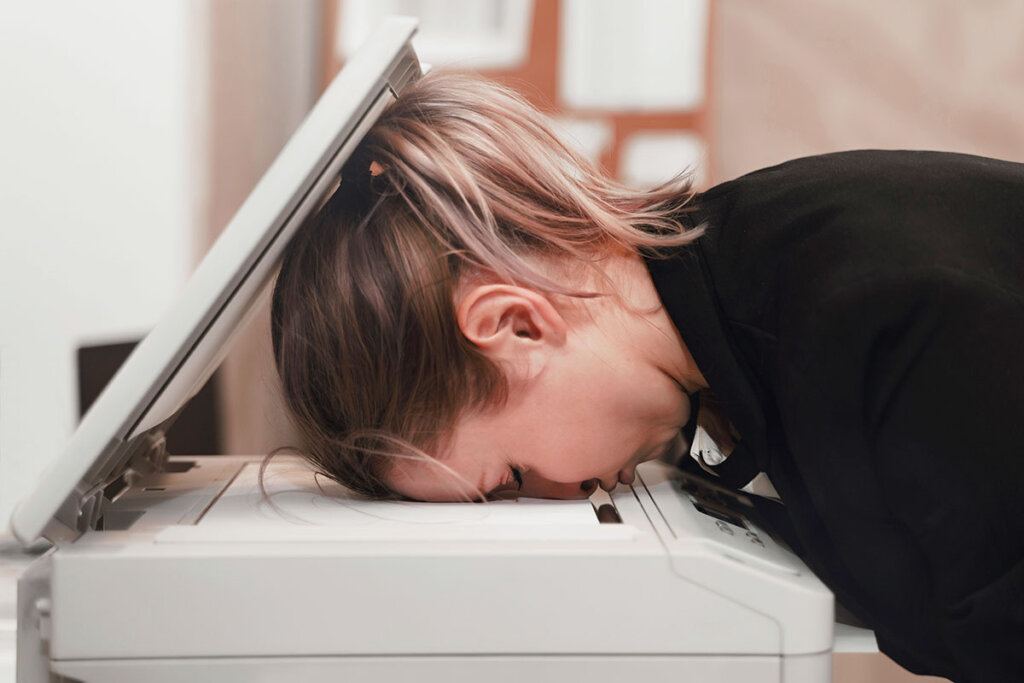 Frau drückt ihren Kopf auf Drucker