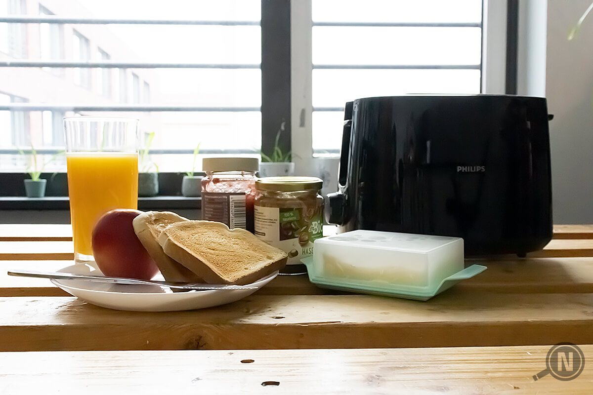 Fruehstueck mit Toaster auf Holzplatte