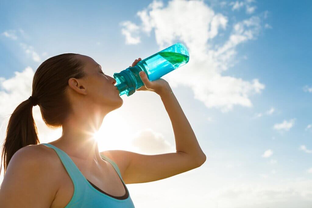 Frau beim Joggen legt Trinkpause ein