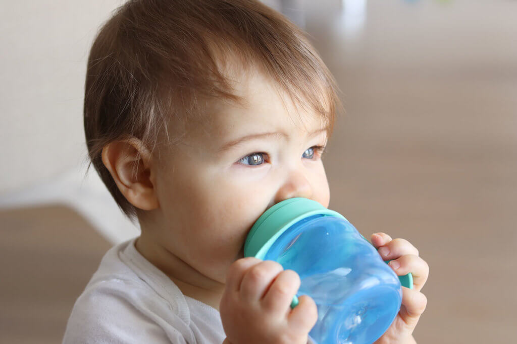 Baby trinkt zuhause aus Trinklernbecher