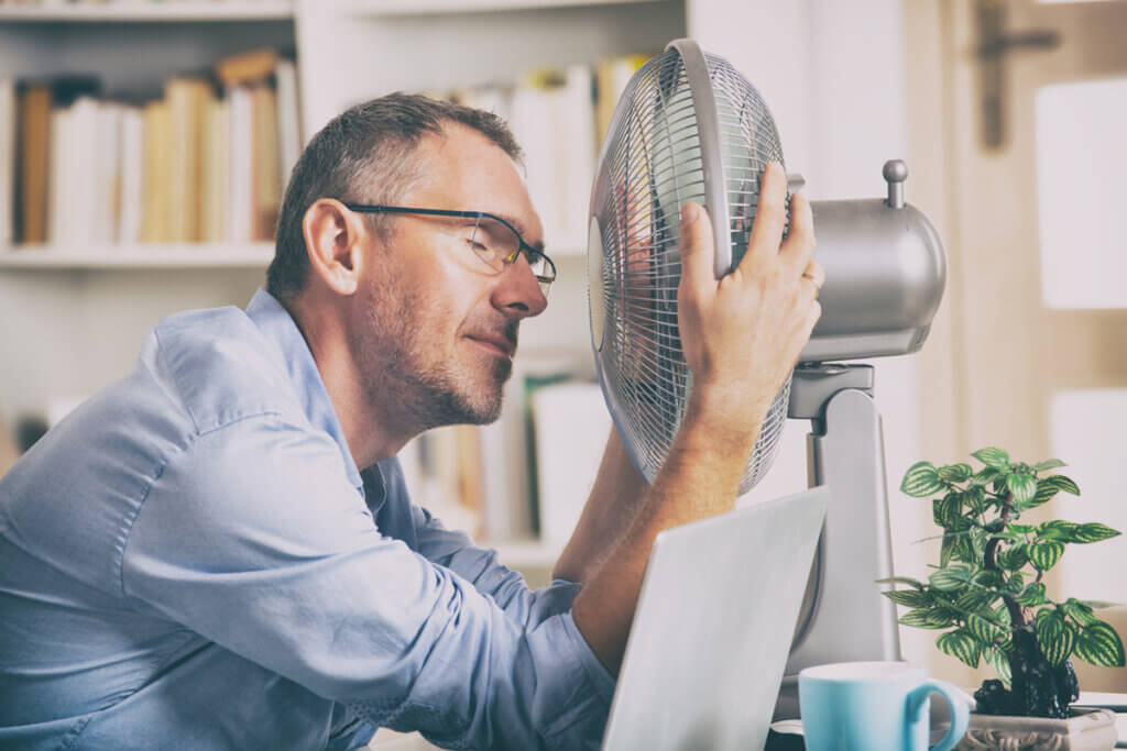 Mann vor Ventilaor in Büro