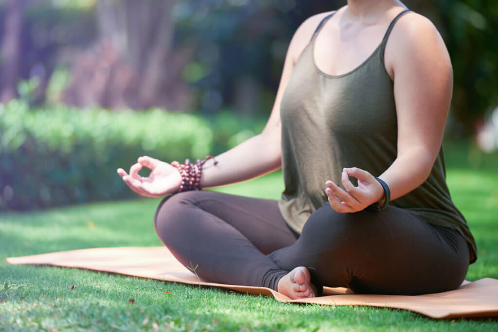 Frau macht Yoga im Garten