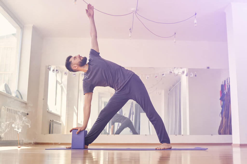 Mann nutzt Yogablock für Übung