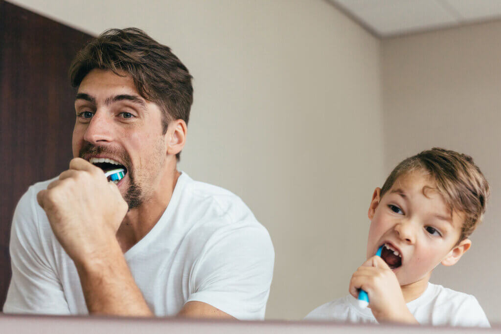 Vater und Sohn putzen Zähne